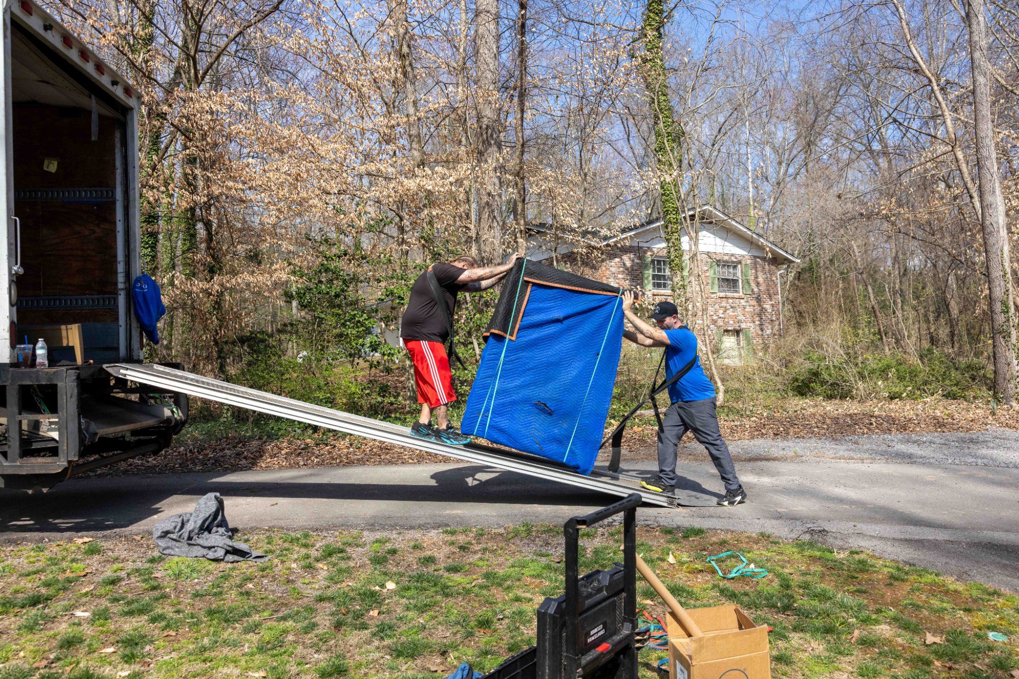 Midas Touch movers loading wrapped furniture up the truck ramp during a long distance move in Sevierville Tennessee