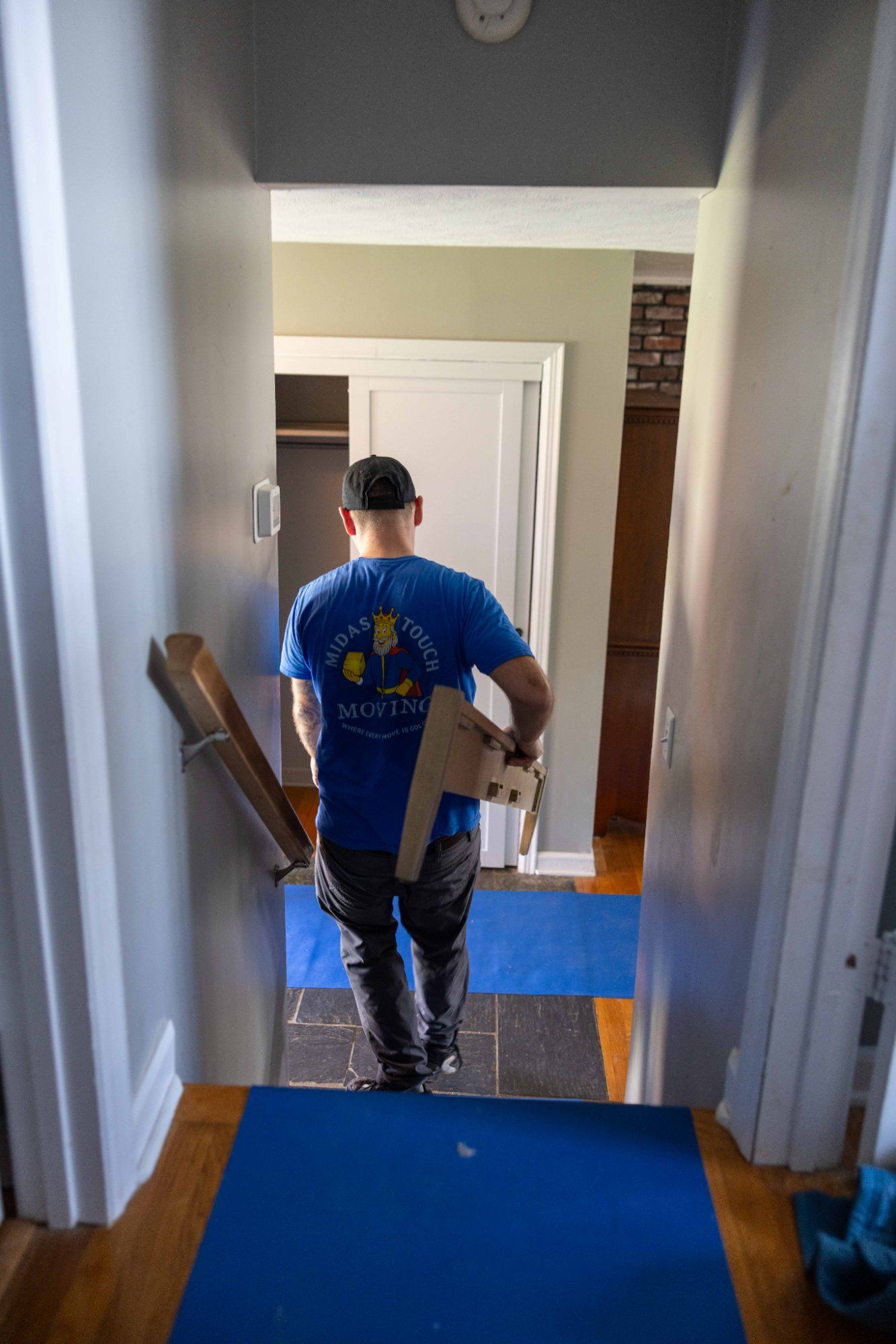 Midas Touch mover carrying a packed box down a hallway during a move with storage in Sevierville TN