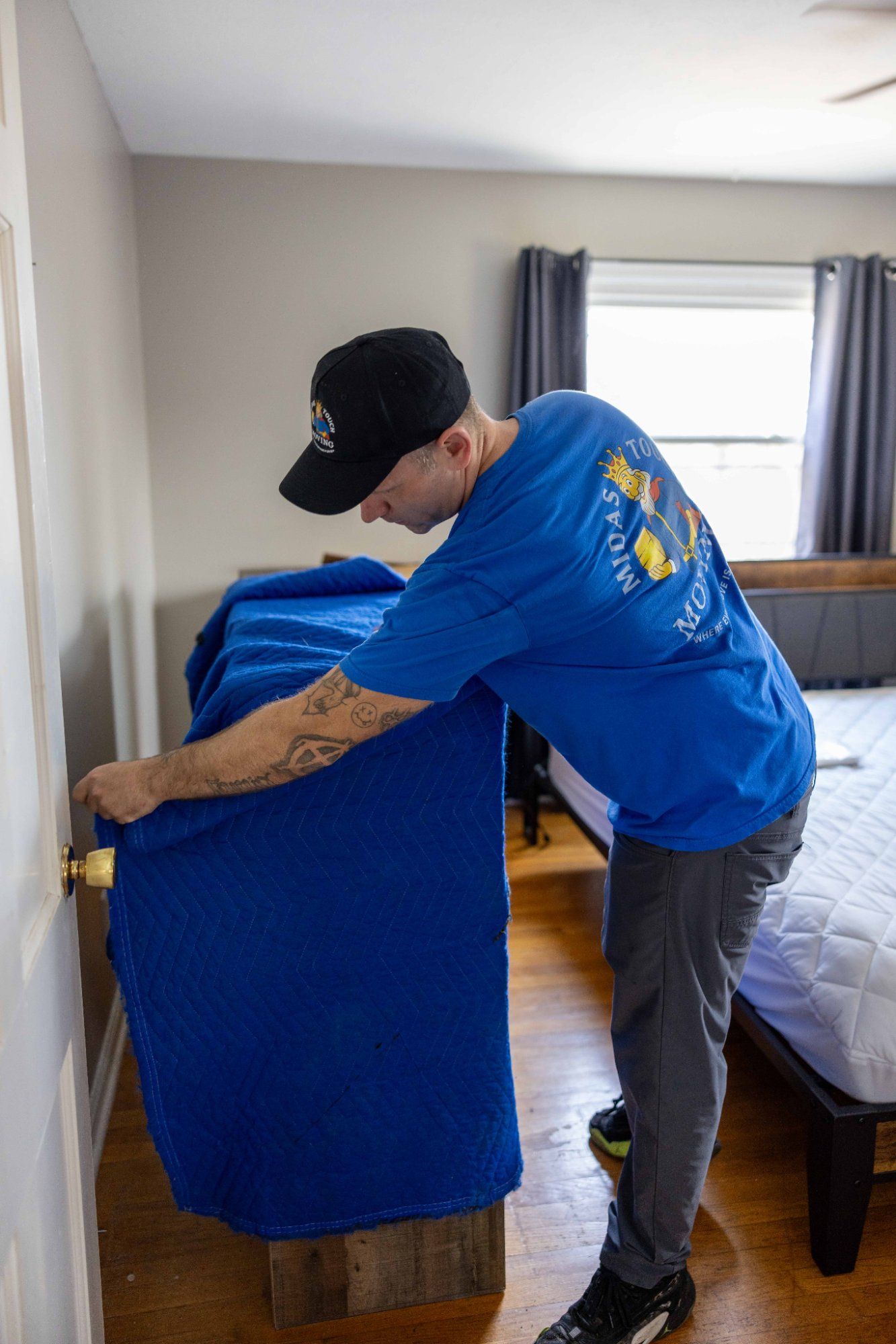Midas Touch Moving crew member wrapping bedroom furniture with professional moving blankets during a local move in Knoxville TN
